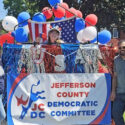 Cropped version of a color photo of Democratic candidates standing with a float in the Carthage parade in 2026