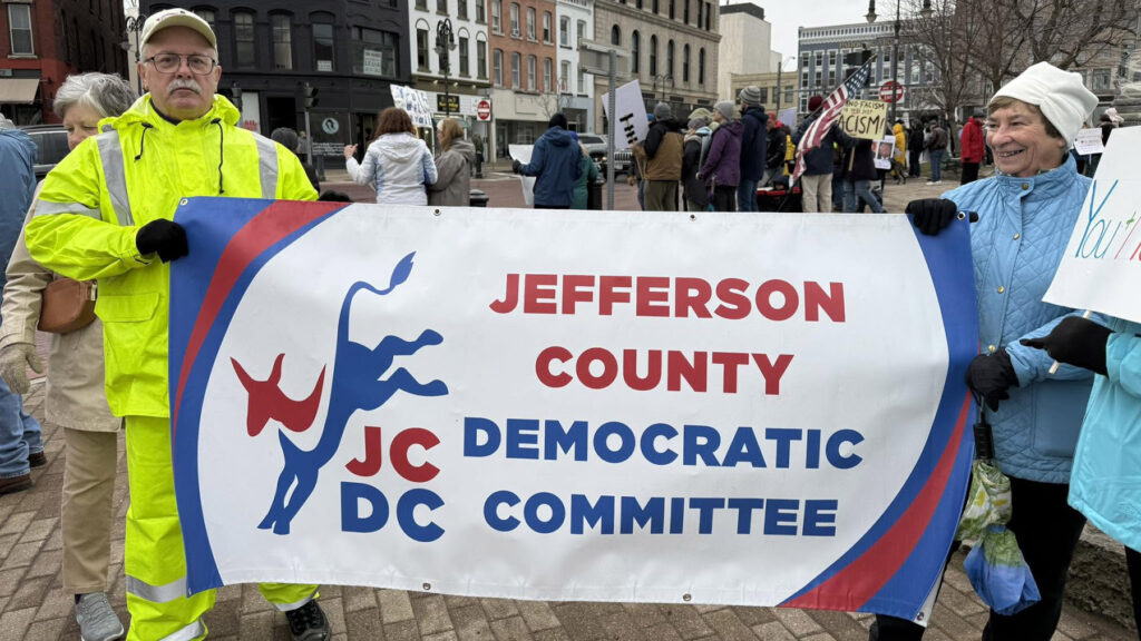 Color photo of members of the Jefferson County Democratic Committee participating in a protest in Watertown's Public Square