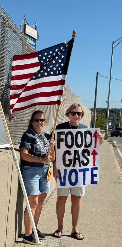 Color photo of two JCDC members participating in the Stronger Together Rally and NYS Bridge Banner Project on Sept 12, 2026 in Watertown